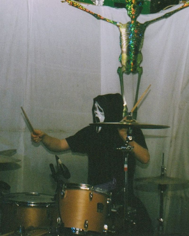 Jack drumming at a gig in a mask